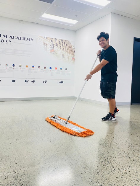 Cleaner using dust mop on shiny floor